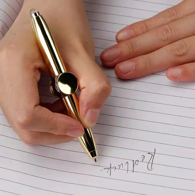 Gold pen being used on lined paper with a hand holding it