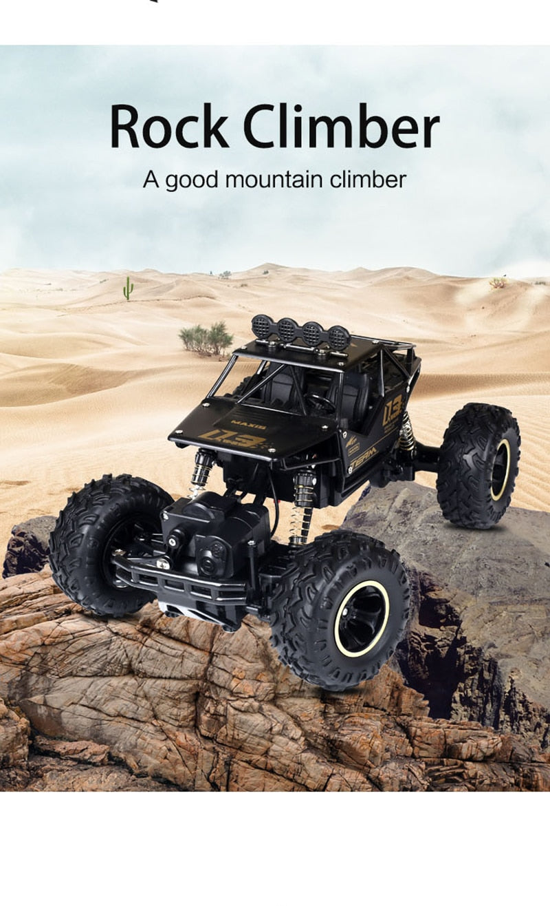 Model of a black off-road vehicle climbing a rocky incline with desert landscape in the background.