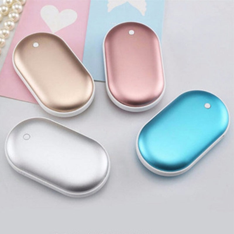Four oval-shaped handheld warmers in gold, pink, silver, and blue on a light gray background.