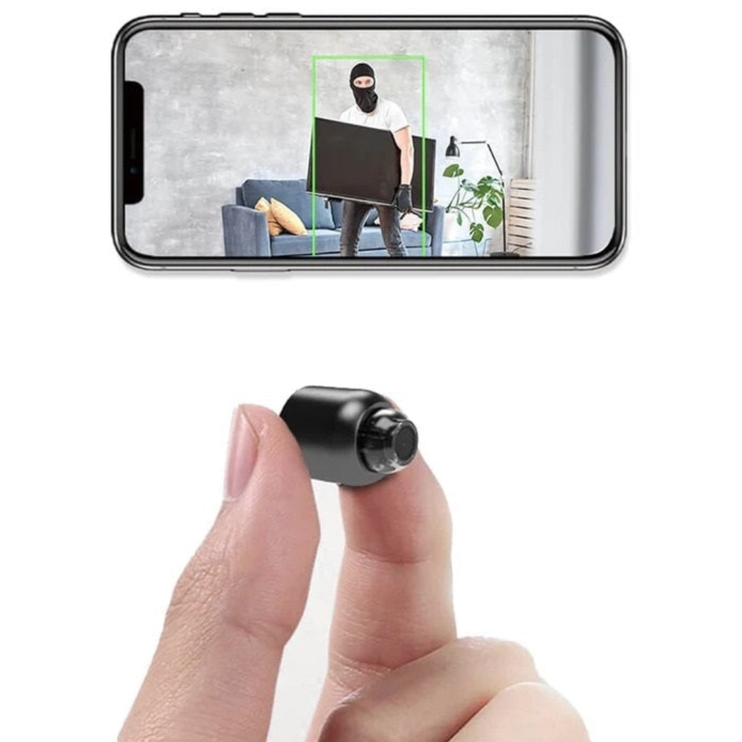 Small camera being held by a finger with a smartphone displaying a surveillance app in the background.